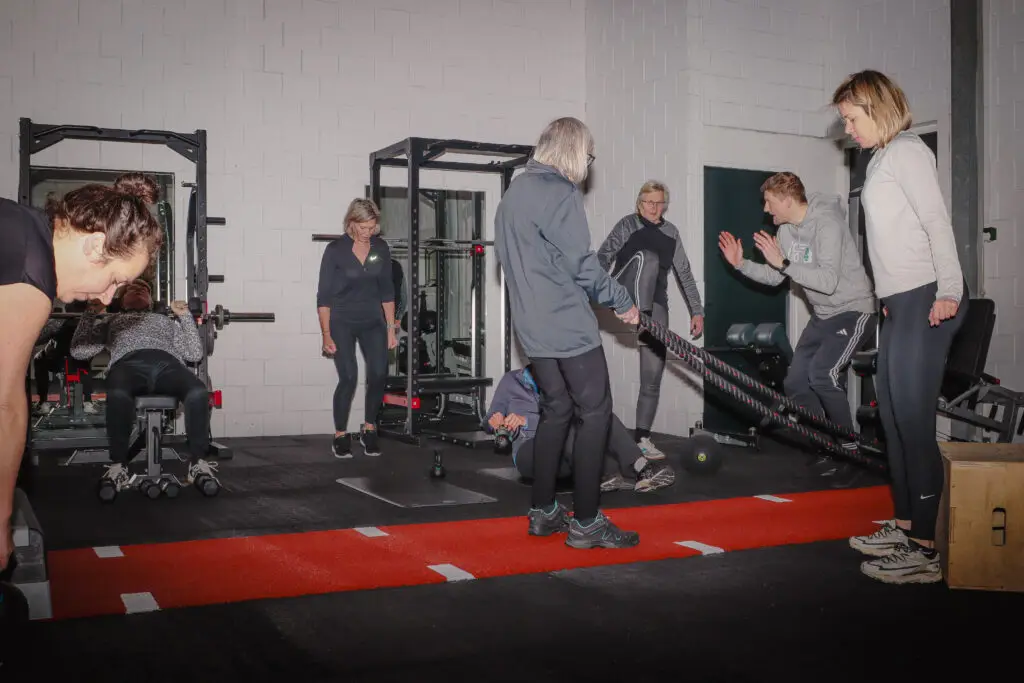 Small group training bij BerkSports: sporters oefenen met battle ropes onder begeleiding van een trainer